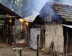 A house burns in Kachugaon village in Kokrajhar, India on Monday, Tens of thousands of villagers have fled their homes in fear of rioting that has killed at least 21 people in recent days in the remote northeast Indian state of Assam.  AP