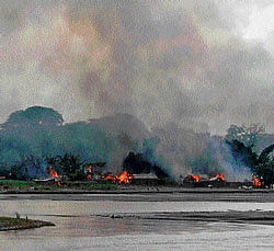 Flames erupt from huts on the banks of river Gourang during violence near Kokrajhar town in Assam on Tuesday. REUTERS