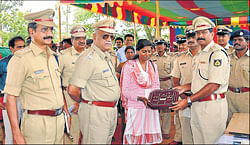 Property parade: (left) SP P Rajendraprasad returns valuables to its owner at a property parade held in Chamarajanagar on Thursday.