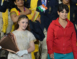 An unidentified woman (R) walks with the Indian delegation during the opening ceremony at The Olympic Stadium in London on July 27, 2012, for the London 2012 Olympic Games. Olympics organisers on July 29, 2012, blamed an 'over-excited' cast member for gatecrashing India's athletes' march at the opening ceremony, denying she was a security risk. The appearance of the mysterious woman, smiling and wearing a red top, next to India's flag-bearer Sushil Kumar at Friday's ceremony caused consternation among the delegation, who demanded an explanation. AFP