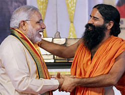 Gujarat Chief Minister Narendra Modi shares a light moment with Baba Ramdev during an award function in Ahmedabad on Sunday. PTI
