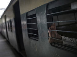 A commuter sleeps inside the compartment of a stationary train following the power outage that struck in the early hours of Monday, July 30, 2012, at a train station in New Delhi, India. Northern India was plunged into darkness Monday after a supply grid tripped because of overloading, officials said. AP