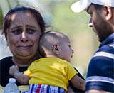 Unsure of the whereabouts of her family members, a woman waits to be escorted into the building of survivors after a shooting at the Sikh Temple of Wisconsin in Oak Creek, Wis., on Sunday, Aug. 5, 2012. An unidentified gunman killed six people at the suburban Milwaukee temple on Sunday in a rampage that left terrified congregants hiding in closets and others texting friends outside for help. The suspect was killed outside the temple in a shootout with police officers. (AP Photo)
