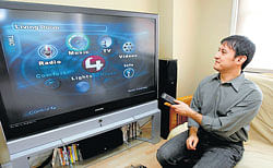 A demonstrator controls TV and other electronic equipment from a hand-held remote in his home in New York.  File photo NYT
