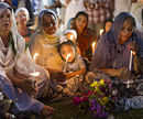 People attend a candle light vigil for the victims of Sunday's shooting at the Sikh Temple of Wisconsin, Tuesday, Aug. 7, 2012, during the national night out event at the Oak Creek Civic Center in Oak Creek, Wisconsin. AP