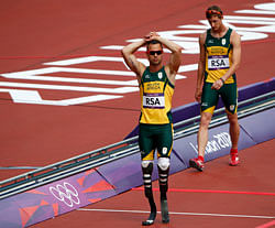 South Africa's Oscar Pistorius (L) and Willem de Beer react after their team did not finish in the men's 4x400m relay round 1 heat during the London 2012 Olympic Games at the Olympic Stadium August 9, 2012. REUTERS