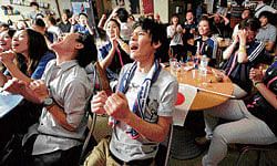 AGONY AND ECSTAsY: Japan's women soccer team fans react as Japan failed to score a goal at a sports bar in Osaka, western Japan as they watch a live broadcast of their team taking on the U.S. women for the Olympic soccer gold medal in London. AP