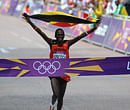 Uganda's Stephen Kiprotich waves his national flag while crossing the finish line to win the athletics event men's marathon during the London 2012 Olympic Games on August 12, 2012 in London. AFP