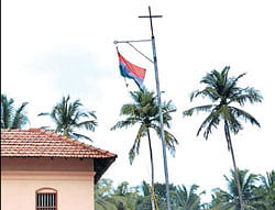 Tricolour hoisted on a flag post which has Cross at the top, outside the house of the Bishop of Malakara Catholic Church at Parladka in Puttur on Wednesday. DH Photo
