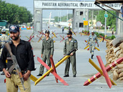 Pakistani Air Force personnel and police cordon the main entrance of the air force base following an attack in Kamra about 60 kilometres northwest of Islamabad on August 16, 2012. Militants armed with guns and rocket launchers stormed a key Pakistani air force base before dawn on August 16, sparking heavy clashes with security forces, officials said. AFP PHOTO