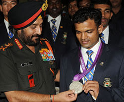 Indian Army Chief General Bikram Singh (L) poses with Olympic silver medal winner Vijay Kumar during an award function for Indian Army olympians at the army headquarters in New Delhi on August 16, 2012. India collected six medals and no golds at the Olympics, saying that the modest haul was a record and efforts were already under way to improve. AFP PHOTO