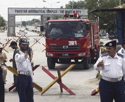 Police officers make way for a firetruck at it leaves Pakistan's air force base in Kamra about 85 kilometers (50 miles) northwest of Islamabad, Pakistan, Thursday, Aug. 16, 2012. Militants attacked the air force base filled with F-16s and other aircraft sparking a heavy battle with security forces that left parts of the base in flames, officials said. AP