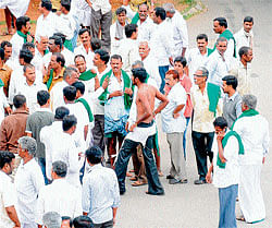 A sugarcane grower with torn inner wear argues with his fellow men, near DCs office in Mysore on Saturday. DH Photo