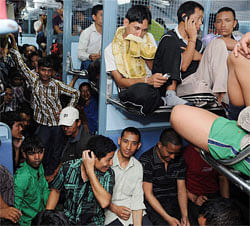 People of North Eastern states sitting in a Assam-bound train at Bengaluru railway station in Bengaluru on Thursday. People from the North Eastern are fleeing the city after rumours of attacks targeting the community in retaliation for communal violence in the state of Assam. PTI Photo
