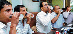 (From left) B Niranjan, Director, Dakshina Kannada Co-operative Milk Union Ltd (DKMUL), president Raviraj Hegde, Director Seetharam Rai drink Nandini milk to ensure that the milk was not poisoned, in Mangalore on Monday.  DH Photo