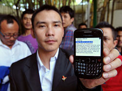 In this photograph taken on August 16, 2012, an Indian northeastern minority resident shows his mobile phone displaying a text message spreading rumours about their safety in the city, in Bangalore. India has demanded social networking websites take down provocative messages and has blocked some online content after anonymous threats sparked an exodus of migrants from several cities. AFP PHOTO/ Manjunath KIRAN