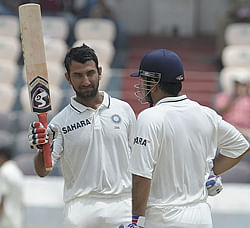 Cheteshwar Pujara raises his bat after scoring 150 runs during the second day of the first Test cricket match between India and New Zealand at the Rajiv Gandhi International cricket stadium in Hyderabad on August 24, 2012. AFP PHOTO