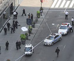 Police surround a sheet covered body on a Fifth Avenue sidewalk as they investigate a multiple shooting outside the Empire State Building, Friday, Aug. 24, 2012, in New York. AP