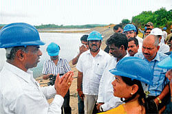 Energy Minister Shobha Karandlaje seeking details from UPCL officials in the project site near Padubidri on Friday. The flyash pond is seen in the background. DH photo