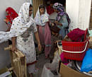 Christian women collect their belongings to leave their home in a suburb of Islamabad, Pakistan on Thursday, Aug. 23, 2012. AP
