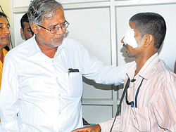 Urban Development Minister Suresh Kumar speaks to Suresh, a photographer injured during the inauguration of the Statecon 2012. dh photo
