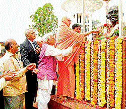 Suttur seer Sri Shivaratri Deshikendra Swamiji offers floral tribute to the bust of Mahatma Gandhiji at Mahatma Gandhi Vana at KSOU&#8200;campus in Mysore on Saturday. Former V-C&#8200;of Agriculture University Mahadevappa, KSOU&#8200;dean T&#8200;D&#8200;Devegowda, VCs K&#8200;Narayan Gowda and K&#8200;S&#8200;Rangappa and gandhian H&#8200;Srinivasaiah are seen.
