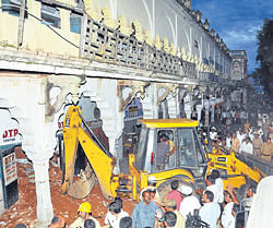 An earth moving machine removes debris at Lansdowne Building in Mysore on Saturday.