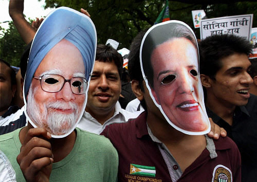 Bharatiya Janata Yuva Morcha activists wear masks of Prime Minister Manmohan Singh and UPA Chairperson Sonia Gandhi during a protest over coal scam at Jantar Mantar in New Delhi on Wednesday. PTI Photo by Kamal Singh