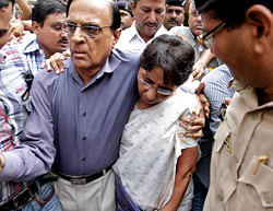 Former Gujarat minister and a member of India's main opposition Bharatiya Janata Party (BJP) Maya Kodnani, center, is escorted by her husband on her arrival at a special court in Ahmadabad, India, Friday, Aug. 31, 2012. The special court in western India announced sentences Friday for 32 people, including Kodnani, found guilty of charges ranging from murder to rioting for their part in deadly religious violence in 2002. The religious violence began following a train fire on Feb. 27, 2002, that killed 60 Hindu pilgrims. Muslims were blamed for the fire, leading to weeks of rioting in which Hindu mobs rampaged through towns and villages burning Muslim homes and businesses. (AP Photo/Ajit Solanki)