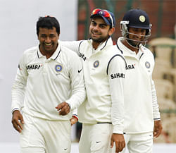 India's Pragyan Ojha (L) celebrates with teammates Virat Kohli (C) and Cheteshwar Pujara after taking the wicket of New Zealand's Tim Southee during the second day of their second test cricket match in Bangalore, September 1, 2012. REUTERS