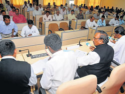 Deputy Chief Minister K S Eshwarappa chairing a review meeting in Udupi on Saturday. District-in-charge Minister Kota Srinivas Poojary among others looks on. DH photo