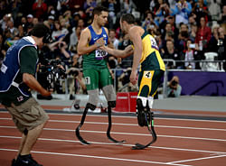 Gold medal winner Brazil's Alan Fonteles Cardoso Oliveira, left, embraces silver medalist south Africa's Oscar Pistorius after they ran the men's 200m T44 category final during the athletics competition at the 2012 Paralympics, Sunday, Sept. 2, 2012, in London. AP