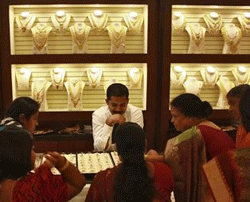 Gold falls from record; importers wait for further drop