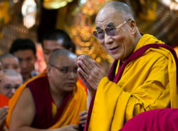 Tibetan spiritual leader the Dalai Lama greets devotees as he arrives to give a religious discourse at the Tsuglakhang temple in Dharmsala, India. AP