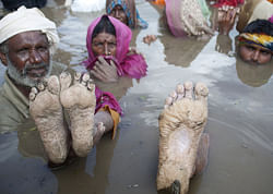 The feet of Bina Bai are displayed as others stand in water during the Jal Satyagraha or insistence on truth by water at Khardana village, in Harda district of the central Indian state of Madhya Pradesh, Tuesday, Sept. 11, 2012. The protesters have been in water reportedly for the past 13 days and are demanding compensation and rehabilitation for villagers whose homes will be submerged under water after opening the gates of the Indira Sagar dam in the state because of rise in water levels of the Narmada River. The protestors say the government's decision to increase the water level of the Indira Sagar without rehabilitating people living in low lying villages is a violation of a court order, which says villagers must be rehabilitated at least six months before such a move is implemented, according to news reports. AP