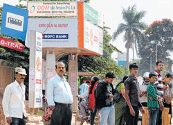 Stranded : People waiting at the NGEF bus stop. DH&#8200;Photos by Dinesh S K