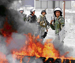 fury over faith: Afghan police stand by burning tyres during a protest against the anti-Islam film on  Monday. AP