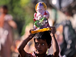 A young Hindu devotee carries home an idol of elephant-headed Hindu God Ganesha on his head in Jammu, India, Wednesday, Sept. 19, 2012. The ten-day long Ganesh festival begins on Sept. 19 and ends with the immersion of Ganesha idols in water bodies on the tenth day. AP