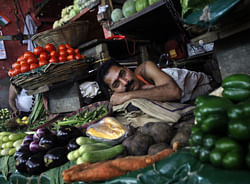 A vendor rests as he waits for customers at a vegetable market in Mumbai September 18, 2012. India's annual consumer price inflation picked up in August to 10.03 percent, driven by a rise in food prices, government data showed on Tuesday. Reuters
