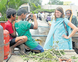 A foreigner poses for a photo amid the rally taken out as part of the bandh in Mysore. DH photo