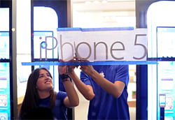 Apple employees hang an iPhone 5 sign at one of the company's retail locations shortly before sales began in San Francisco, California, September 21, 2012. Apple fans queued around city blocks worldwide on Friday to get their hands on the new iPhone 5 - but grumbles about inaccurate maps tempered the excitement. REUTERS