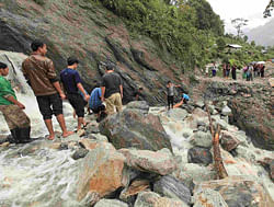People work to remove the debris caused by a landslide in Chungthang, in the northeastern Indian state of Sikkim, September 23, 2012. Floods and landslides caused by relentless rain in northeast India have killed at least 33 people and displaced more than a million over the past week, officials said on Monday. Picture taken September 23, 2012. REUTERS