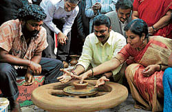 Tourism Minister Anand Singh and MLC Tara try their hands at pottery at the Karnataka Tourism Crafts Mela held to mark World Tourism Day in Bangalore on Thursday. DH Photo