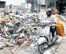 Uncleared garbage claims a lions share of the Kempe Gowda Road in Bangalore on Thursday. DH Photo / Savitha B R