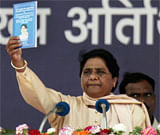 BSP supremo Mayawati shows a book while addressing a party rally on the occasion of party founder Kanshiram's sixth death anniversary in Lucknow on Tuesday. PTI Photo