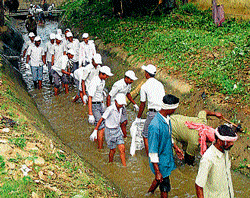 Students of Government Industrial Training Institute in Mandya, along with  volunteers, clean up a canal in Mandya on Friday. DH Photo