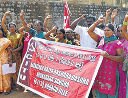 The Akshara Dasoha employees stage a protest demanding the fulfillment of various demands in Madikeri recently. DH Photo