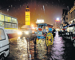 downpour:  Vehicles,  including a tonga,  wade through the waters following heavy rains that lashed Mysore on Sunday evening. dh photo