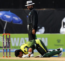 In this photograph taken on April 13, 2008, Pakistani batsman Kamran Akmal bows down to the ground after scoring a century (100 runs) against Bangladesh as field umpire Nadeem Ghouri (rear) looks on during the third One-Day International cricket match between Pakistan and Bangladesh at The Gaddafi Cricket Stadium in Lahore. Umpires at the centre of a bribery scandal denied October 9, 2012, that they were willing to fix matches for cash as cricket authorities announced an urgent probe into the allegations aired in a television sting. An undercover investigation by the private India TV channel allegedly found that six umpires, including one who is a regular fixture on the international circuit, were willing to give decisions or provide inside information on the teams and playing conditions in return for illicit payments. AFP PHOTO