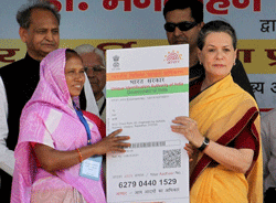 UPA Chairperson Sonia Gandhi delvers 21st crore Aadhar card to a woman during launch of 'Aadhaar Enabled Service Delivery' on the 2nd anniversary of Adhaar Card at Dudu near Jaipur on Saturday. PTI